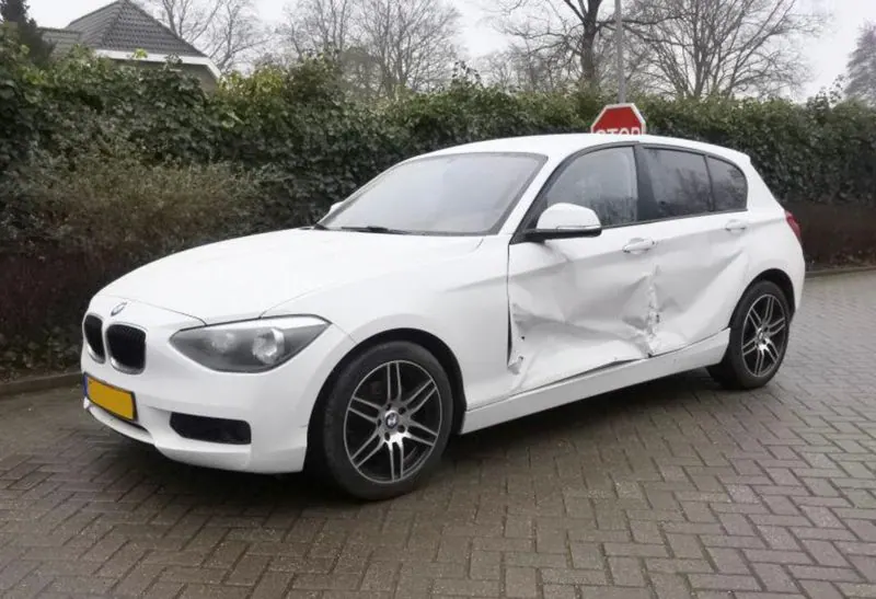 BMW met zichtbare schade aan twee portieren en de dorpel